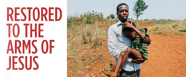 An EHC worker holds a young boy as he prays for him. 